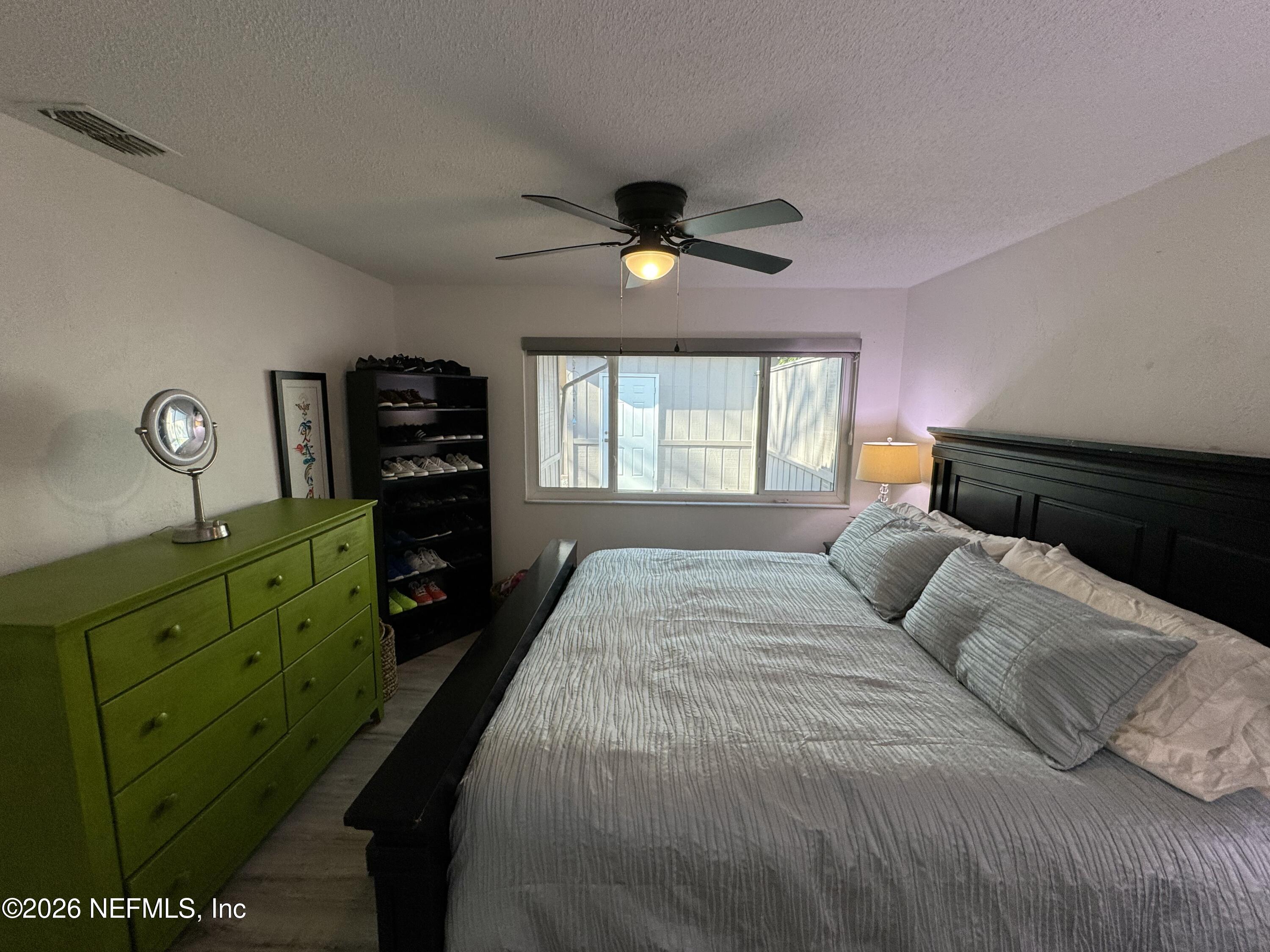 49 Cypress Pond Road Port Orange, FL 32128 - Photo 11 of 16 a bedroom with a bed a chandelier and a window