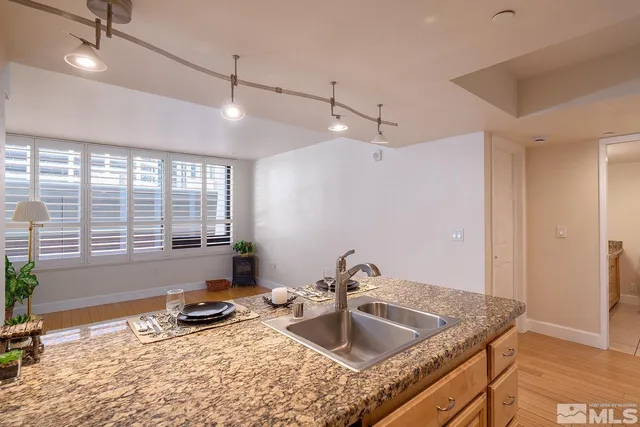 a bathroom with a granite countertop sink a mirror and a shower