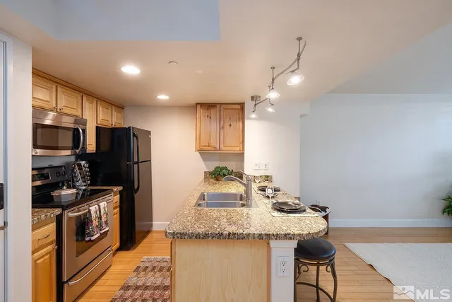 a kitchen with stainless steel appliances granite countertop a sink refrigerator and microwave