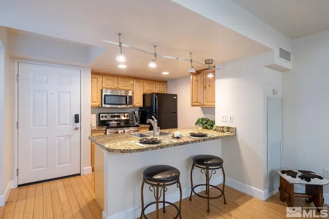 a kitchen with stainless steel appliances granite countertop a stove refrigerator and cabinets