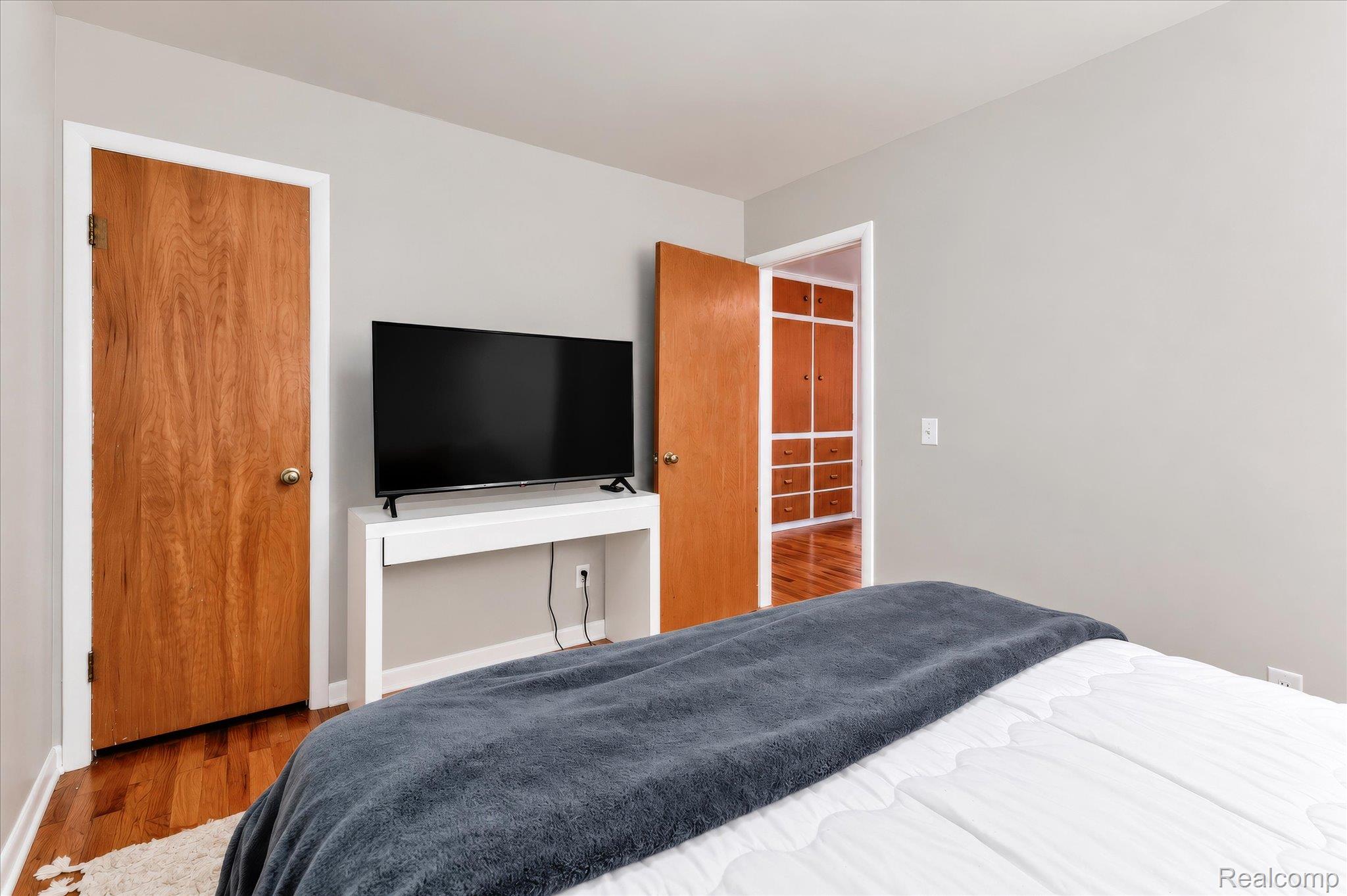4499 South Linden Road Flint, MI 48507 - Photo 20 of 32 Hardwood flooring, light gray wall finish, built-in shelving, wood-finish doors, white trim