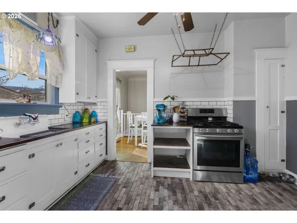 a kitchen with granite countertop a stove and white cabinets
