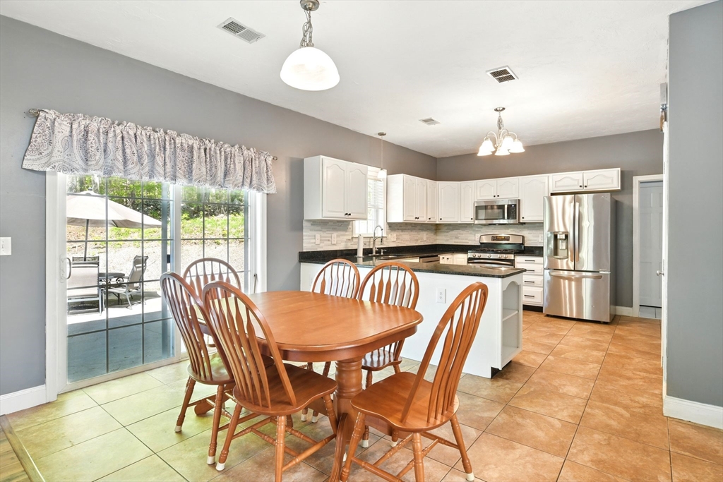 28 Ayers Road Monson, MA 01057 - Photo 13 of 42 a kitchen with granite countertop a refrigerator a stove a sink a dining table and chairs