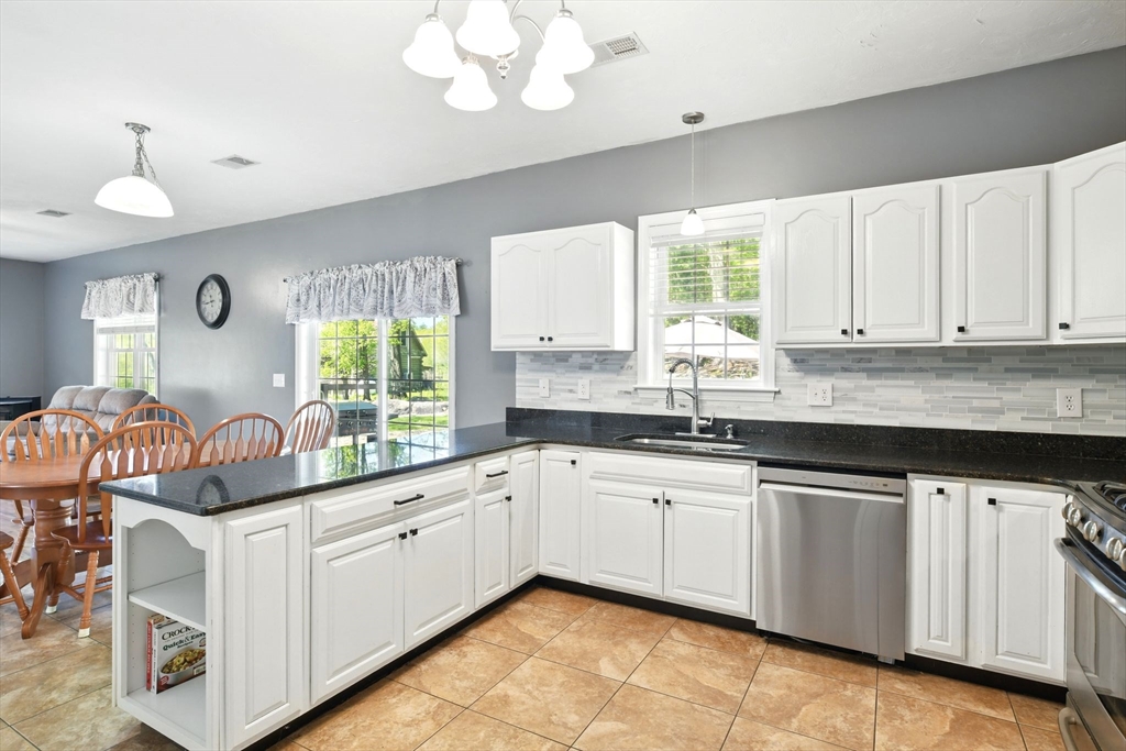28 Ayers Road Monson, MA 01057 - Photo 18 of 42 a kitchen with granite countertop white cabinets white appliances a sink and a window