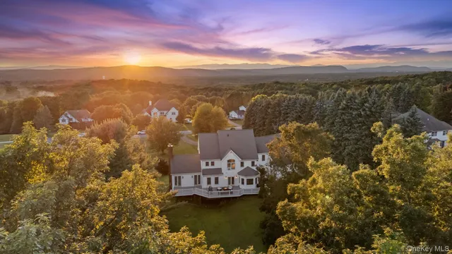 a view of a big house with a big yard and potted plants