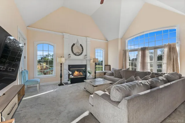 a living room with furniture a large window and a fireplace