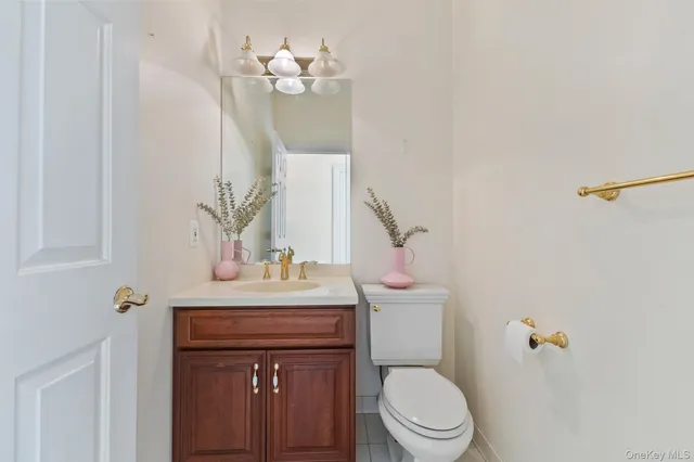 a bathroom with a sink vanity mirror and toilet