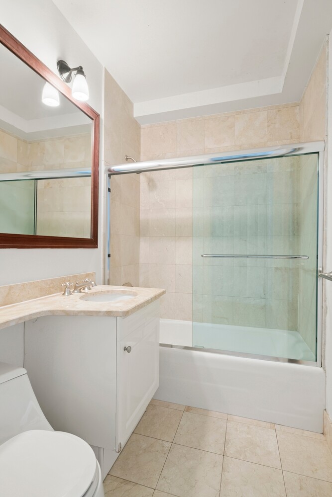 10 West Street, Unit 15C Manhattan, NY 10004 - Photo 15 of 23 a bathroom with a sink a toilet and shower