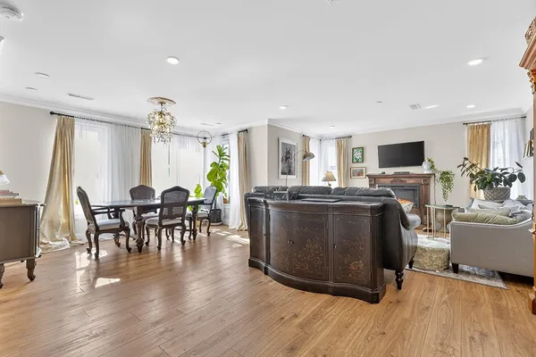 a living room with furniture a fireplace and a dining table with wooden floor