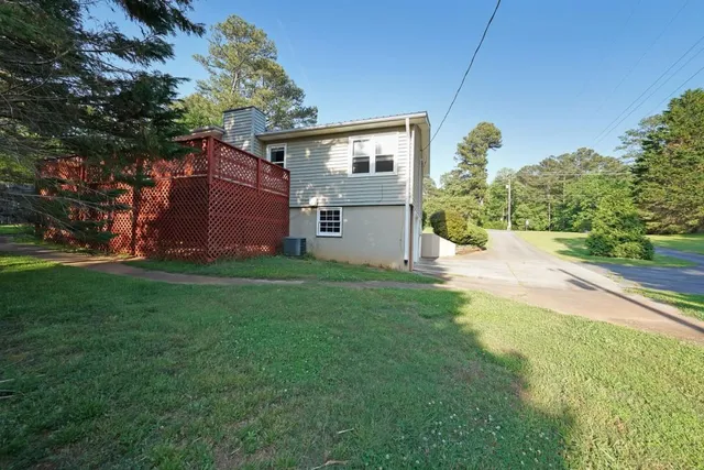 a backyard of a house with plants and large trees