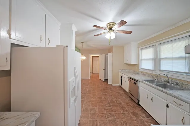 a view of a kitchen with a sink and a refrigerator