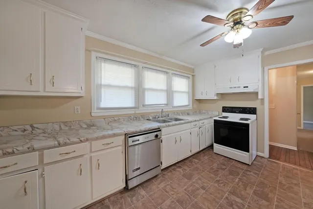 a kitchen with granite countertop white cabinets and white appliances