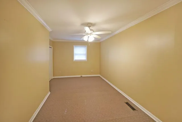 an empty room with a window and a ceiling fan