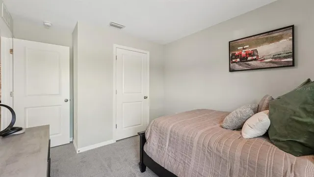a bedroom with a bed and a painting on the wall