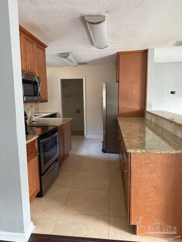 a kitchen with stainless steel appliances granite countertop a stove a sink and a refrigerator