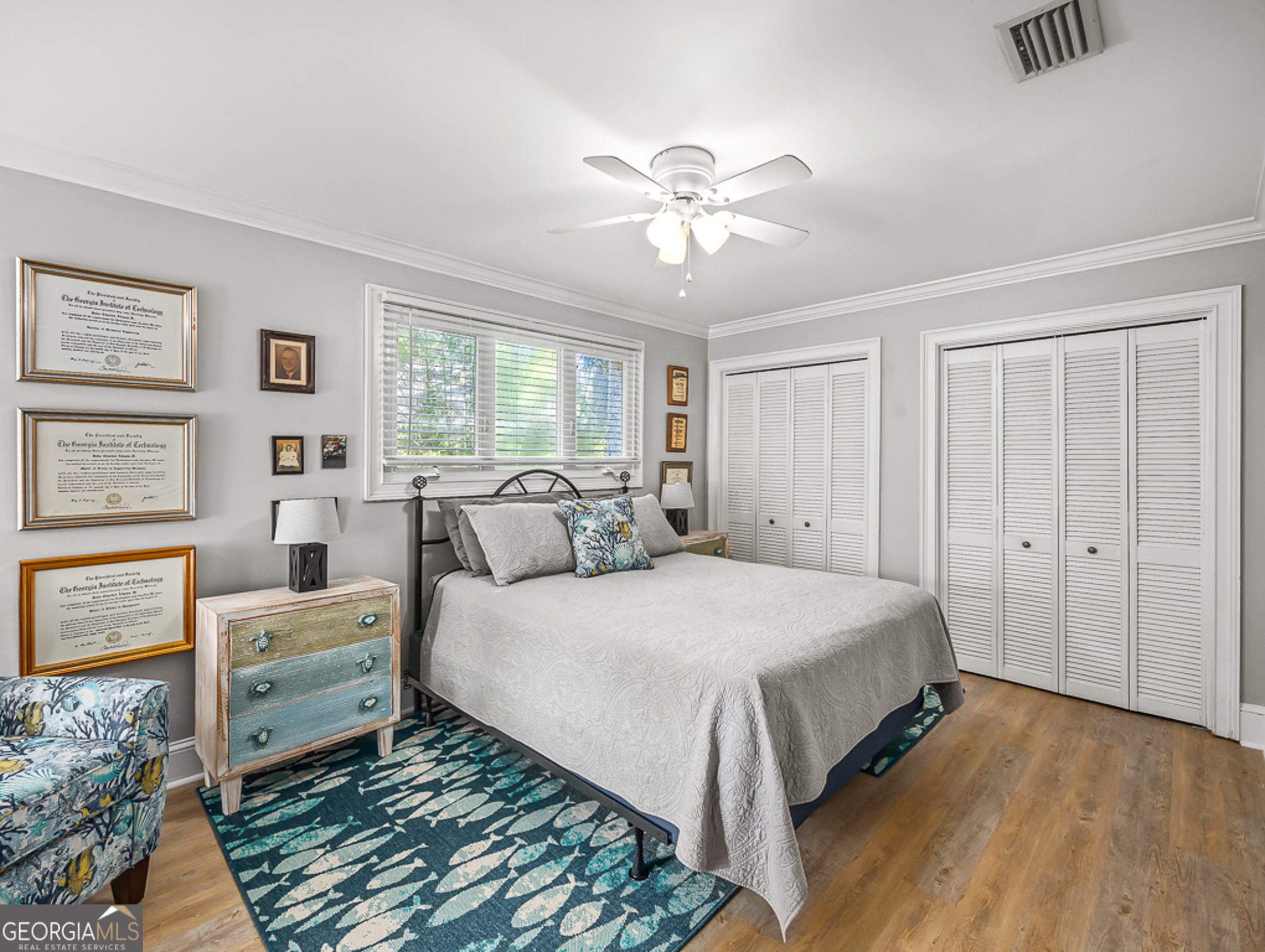 103 Cater Street St. Simons, GA 31522 - Photo 23 of 30 a spacious bedroom with a bed and a chandelier