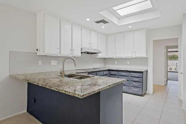 a kitchen with stainless steel appliances granite countertop a sink stove and cabinets
