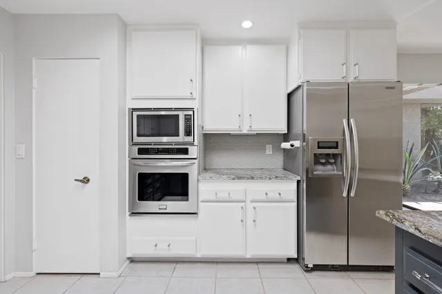 a kitchen with stainless steel appliances granite countertop a refrigerator and a sink