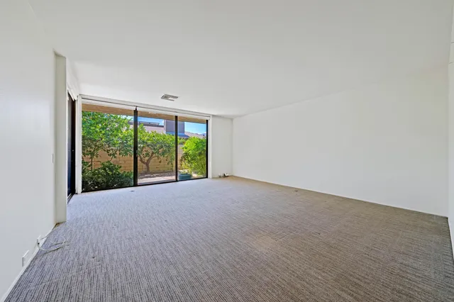 a spacious bedroom with a large bed and a large window