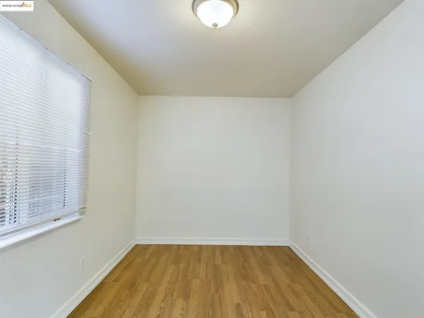 a view of a room with wooden floor and white walls