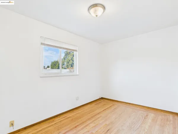 a view of a room with wooden floor and window