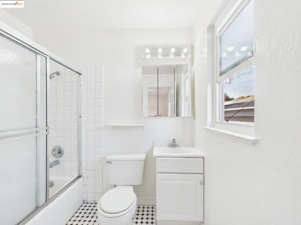 a bathroom with a toilet sink vanity and mirror
