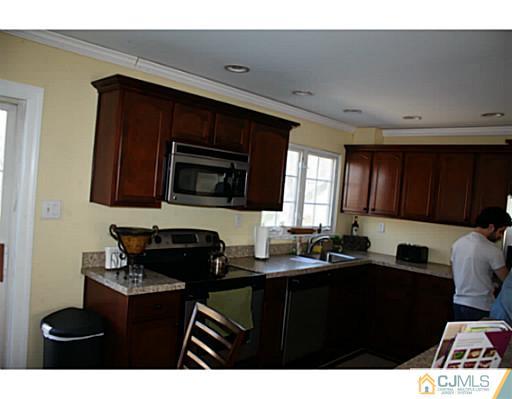 31 Phillips Road Edison, NJ 08817 - Photo 4 of 4 a kitchen with a sink cabinets and black stainless steel appliances