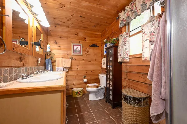 a bathroom with a sink a toilet and a window