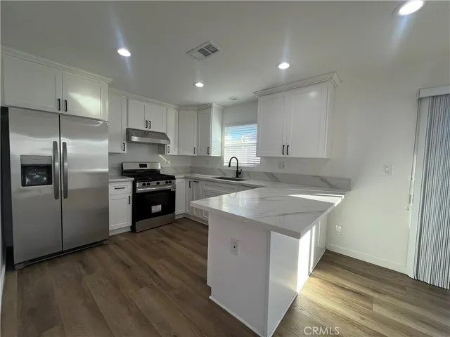 a kitchen with kitchen island a sink stainless steel appliances and counter space