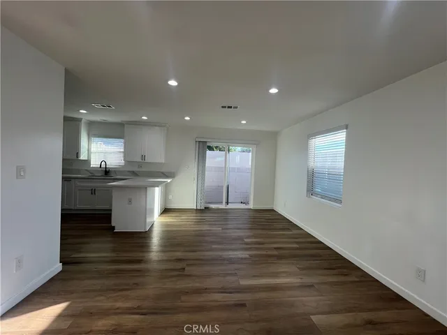 a view of kitchen with a sink wooden cabinets and glass window