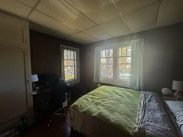 a bedroom with a bed dresser and a window