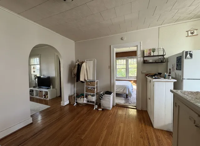 a view of a kitchen with fridge and wooden floor