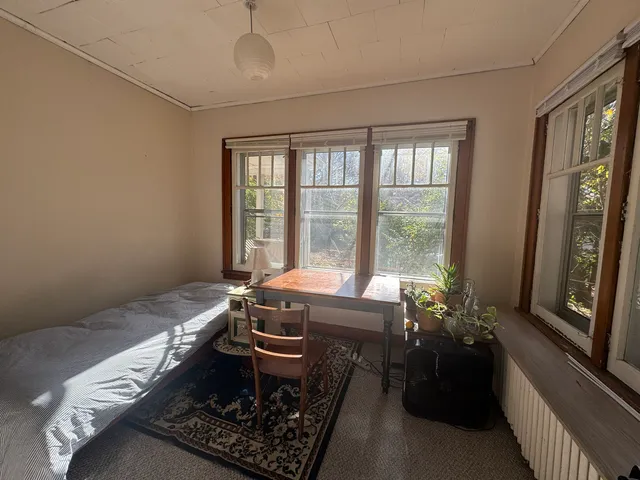 a room with a bed and wooden floor