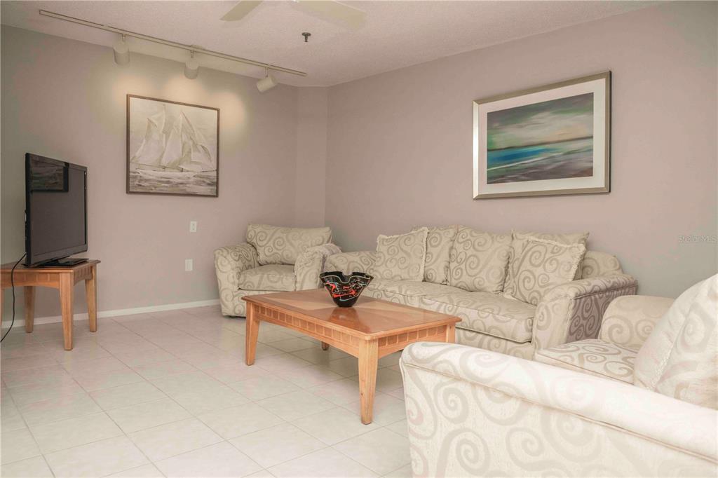 1922 Harbourside Drive, Unit 1102 Longboat Key, FL 34228 - Photo 17 of 23 a living room with furniture a couch and a flat screen tv