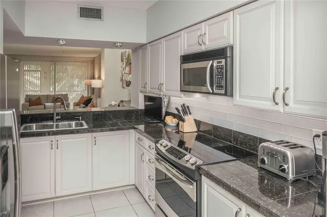 a kitchen with granite countertop a sink stove and cabinets