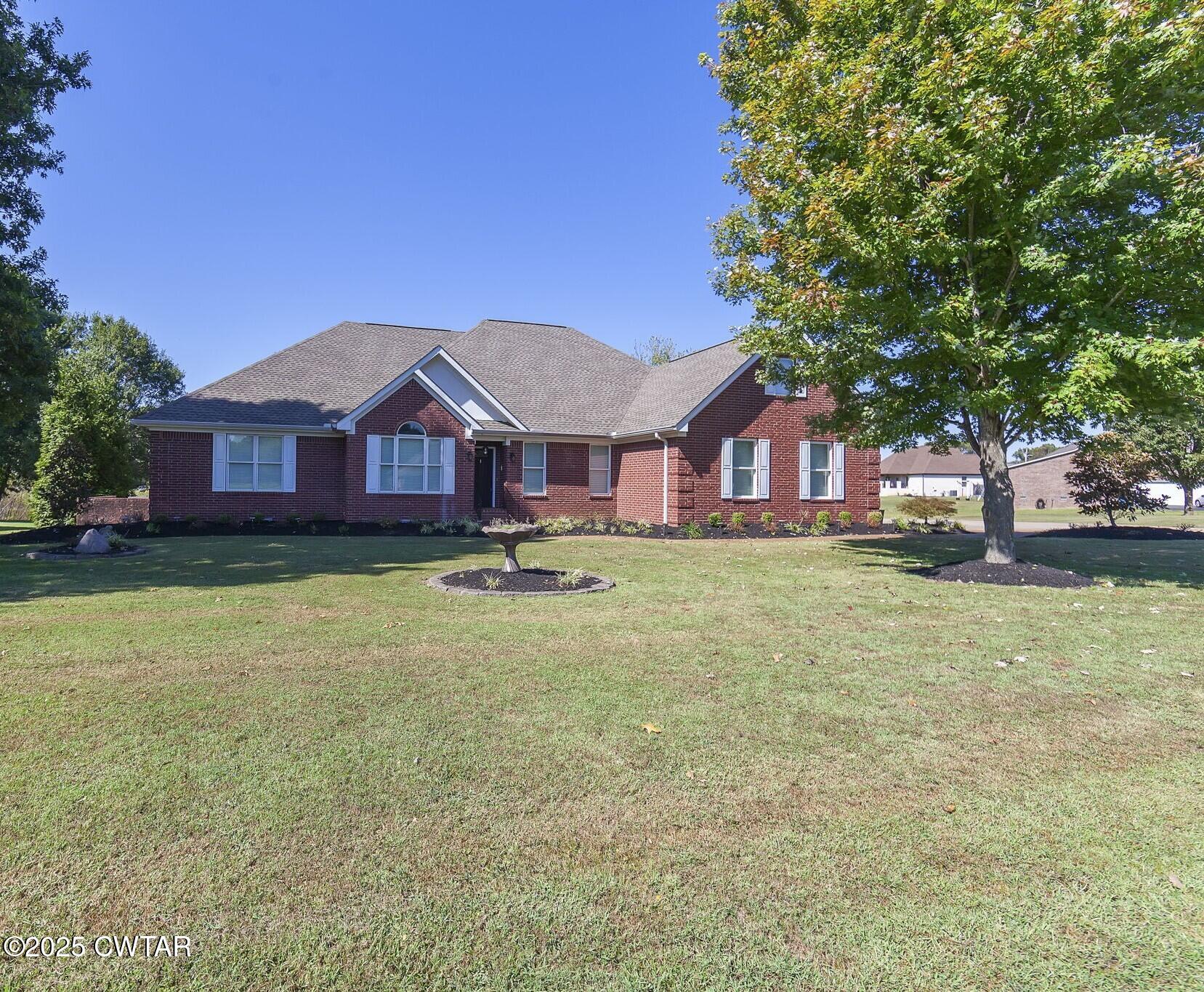 495 Sycamore Lane McKenzie, TN 38201 - Photo 1 of 21 a front view of a house with a garden and tree