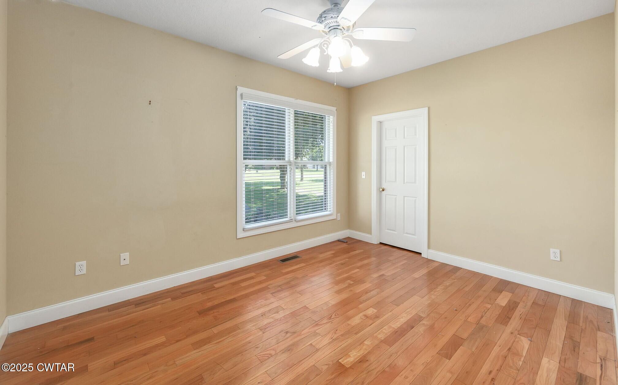 495 Sycamore Lane McKenzie, TN 38201 - Photo 16 of 21 an empty room with wooden floor fan and windows