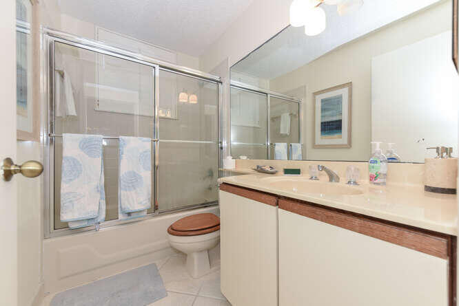 602 Mainsail Circle Jupiter, FL 33477 - Photo 14 of 39 a bathroom with a granite countertop sink a toilet a mirror and shower