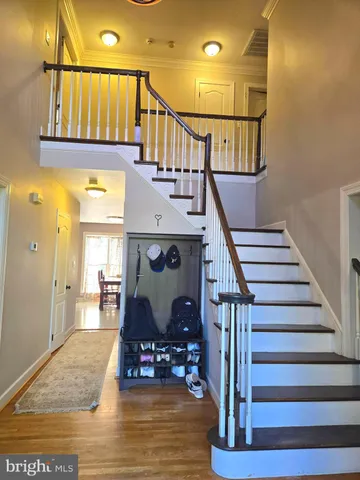 a living room with couches a dining table and a stove with wooden floor