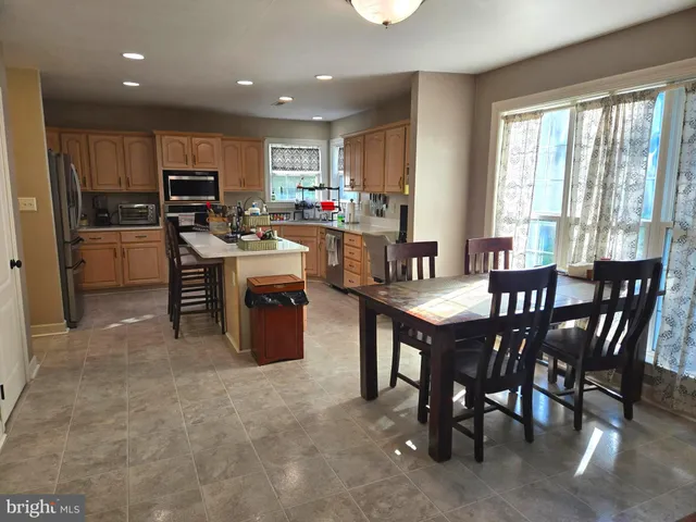 a spacious bedroom with a bed and dresser with mirror