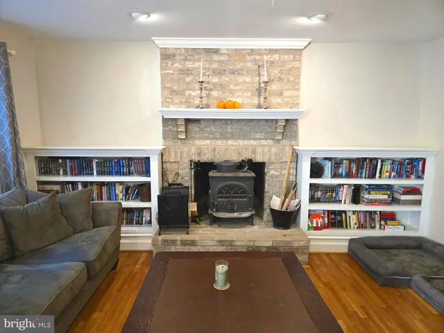 a view of a hallway with wooden floor and furniture