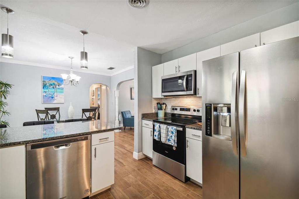 3915 North Ridge Avenue Tampa, FL 33603 - Photo 17 of 52 a kitchen with stainless steel appliances granite countertop a refrigerator a stove top oven a sink and dishwasher