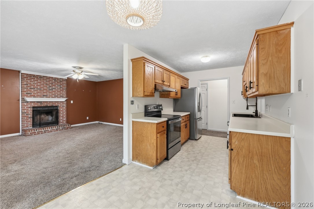207 Cobblestone Court Raeford, NC 28376 - Photo 11 of 35 a kitchen with stainless steel appliances granite countertop a stove a sink and a refrigerator