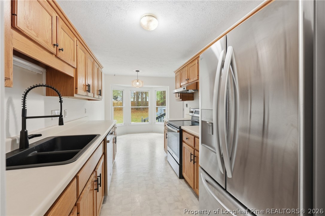 207 Cobblestone Court Raeford, NC 28376 - Photo 15 of 35 a kitchen with stainless steel appliances granite countertop a sink a stove and a refrigerator