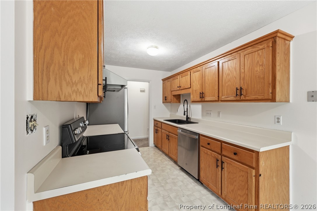 207 Cobblestone Court Raeford, NC 28376 - Photo 16 of 35 a kitchen with stainless steel appliances a sink a stove and a refrigerator
