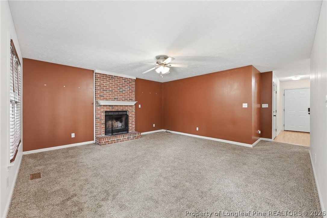 207 Cobblestone Court Raeford, NC 28376 - Photo 21 of 35 an empty room with a fireplace and fan