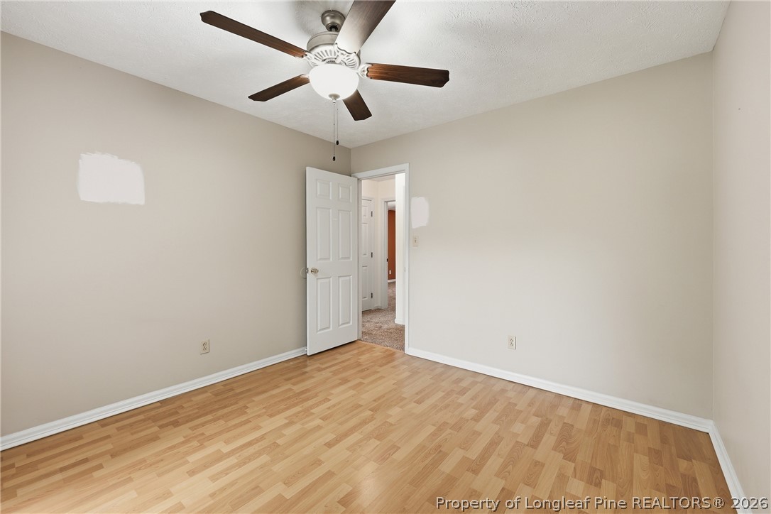207 Cobblestone Court Raeford, NC 28376 - Photo 25 of 35 an empty room with a ceiling fan and wooden floor