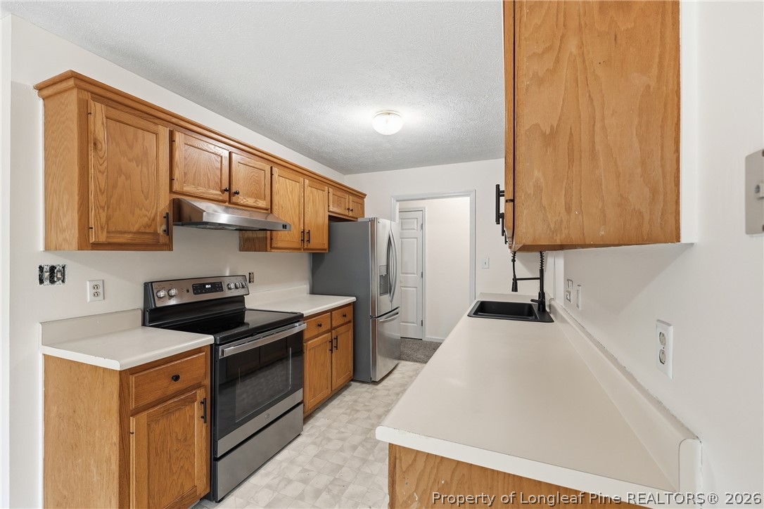 207 Cobblestone Court Raeford, NC 28376 - Photo 27 of 35 a kitchen with stainless steel appliances a stove a sink a refrigerator and cabinets