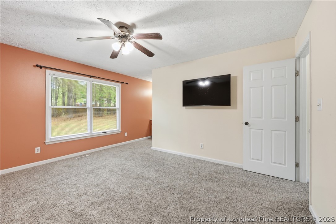 207 Cobblestone Court Raeford, NC 28376 - Photo 29 of 35 en empty room with ceiling fan and window