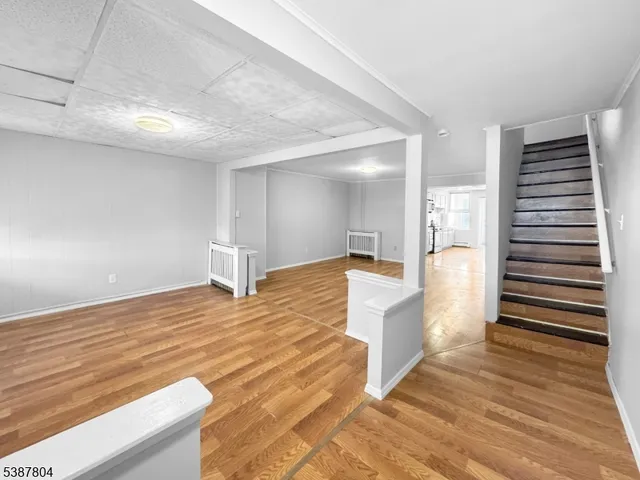 a view of a living room and kitchen space with wooden floor